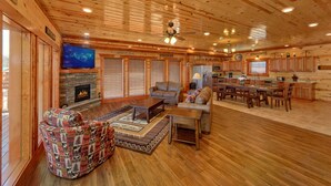 A spacious living area with a fireplace, comfortable seating, and a television.