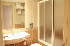 A bathroom with a sink, toilet, and a shower area. - Hotel Jaqués (Jaca)