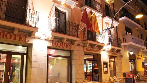 Un hotel con posti a sedere all'aperto e bandiere.