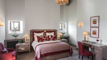 Une chambre à coucher avec un grand lit, des tables de chevet, un bureau et une chaise.