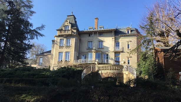 Un grand bâtiment historique doté de nombreuses fenêtres et d’une tour imposante.