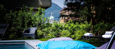 Una piscina al aire libre de temporada, sombrillas