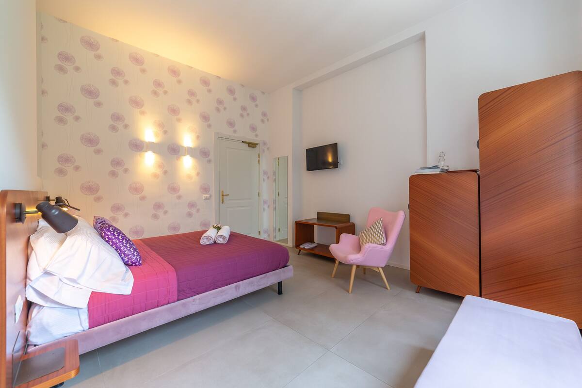 Un dormitorio con cama, escritorio, silla y armario.