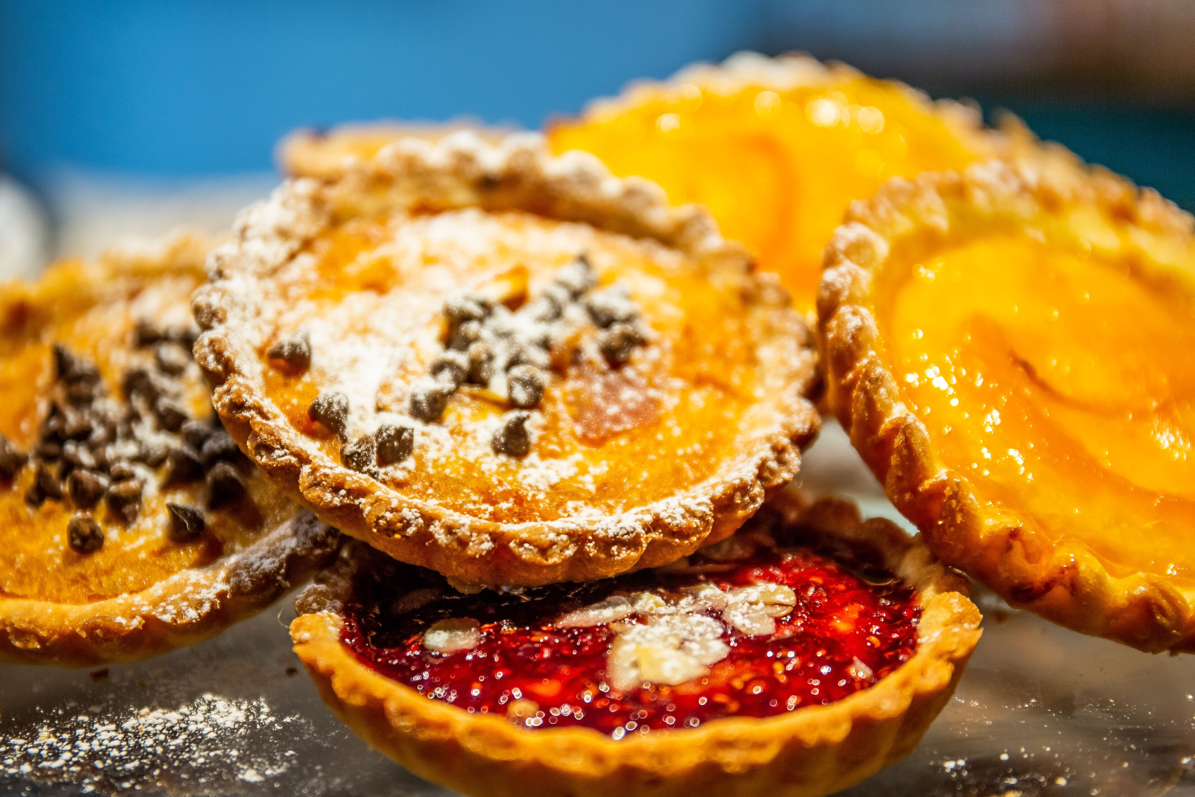 A close-up of various pies with different toppings.