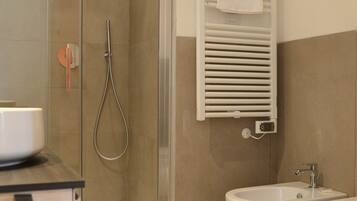 Ein modernes Badezimmer mit einer Duschkabine, einem Bidet und einer Toilette.