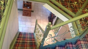 A staircase with a checkered floor and green railings. - Lochview Guesthouse (Strathpeffer)