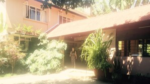 A building with a covered entrance and potted plants. - Outpost Lodge (Arusha)