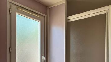 Un baño con ventana, lavamanos y ducha.