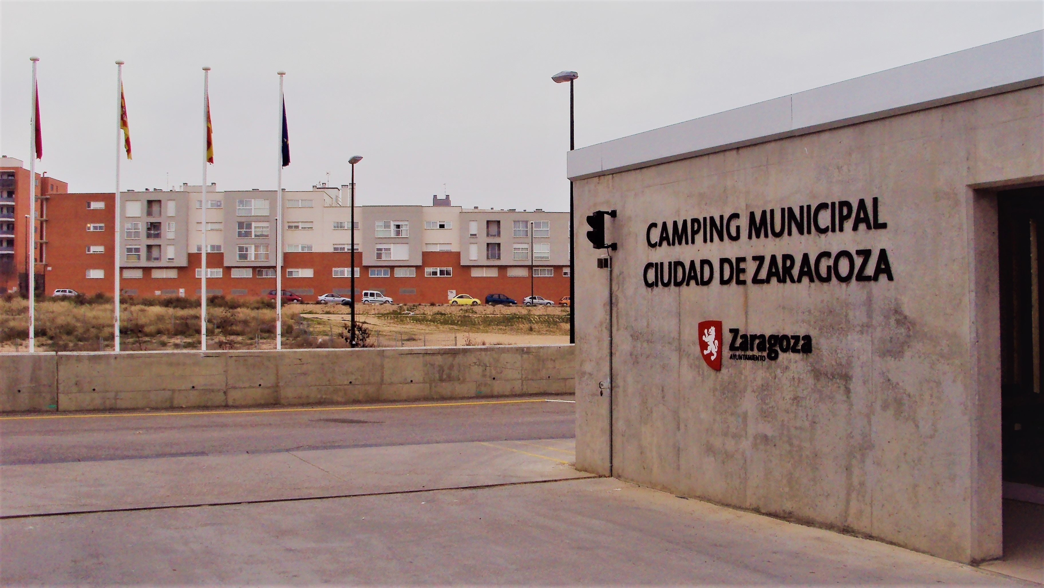 A building with a sign reading "CAMPING MUNICIPAL CIUDAD DE ZARAGOZA".