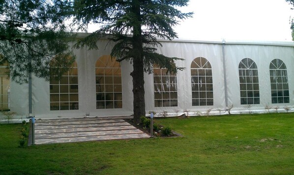 Un edificio grande y blanco con ventanas de arco y un área de acceso empavedada.