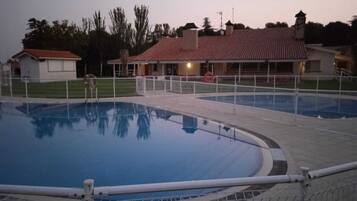 Una piscina con borde de azulejos y una valla.
