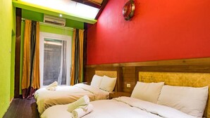 A hotel room with two beds, a red wall, and a window with curtains. - Land of joy Ubud Hall (Hengchun)