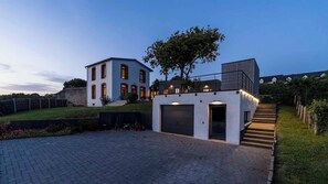 Ein modernes Haus mit Garage, befestigter Auffahrt und kleinem Garten.