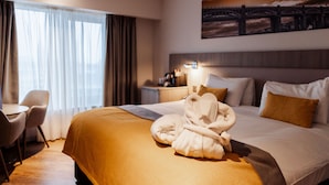 A hotel room with a bed, a desk, a chair, a nightstand, and a painting on the wall. - Maldron Hotel Newcastle (Newcastle-upon-Tyne)