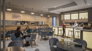 A modern bar area with seating and a bartender. - Maldron Hotel Newcastle (Newcastle-upon-Tyne)