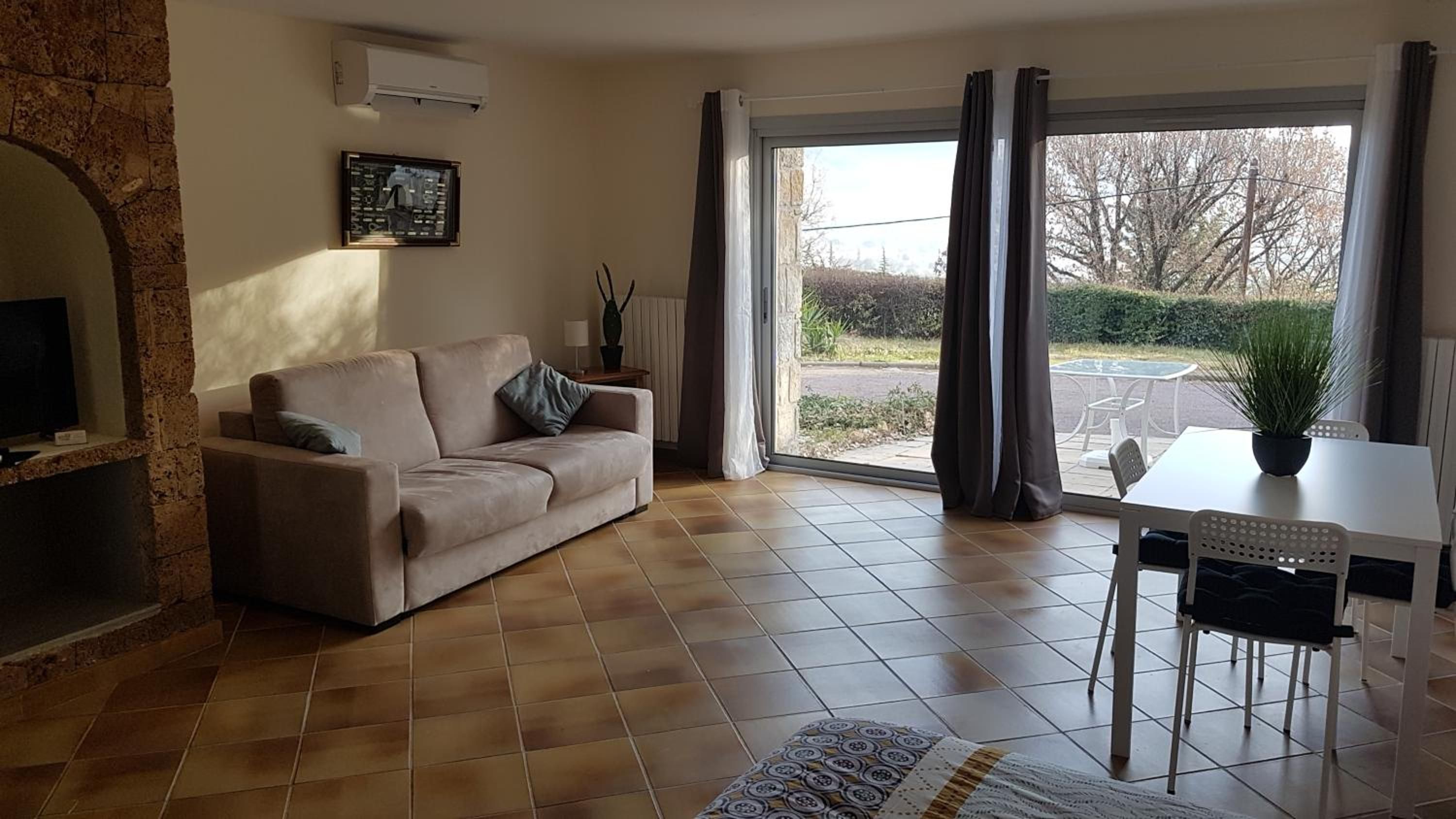 A living room with a sofa, a table, and a potted plant.