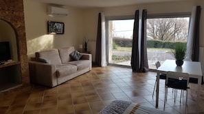 A living room with a sofa, a table, and a potted plant. - Villa Manoé (Draguignan)