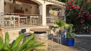 An outdoor patio with round tables and chairs, a decorative metal fence, and potted plants. - Villa Manoé (Draguignan)