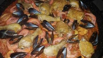 Una olla gran i rodona plena de marisc, probablement un estufat de marisc o paella.