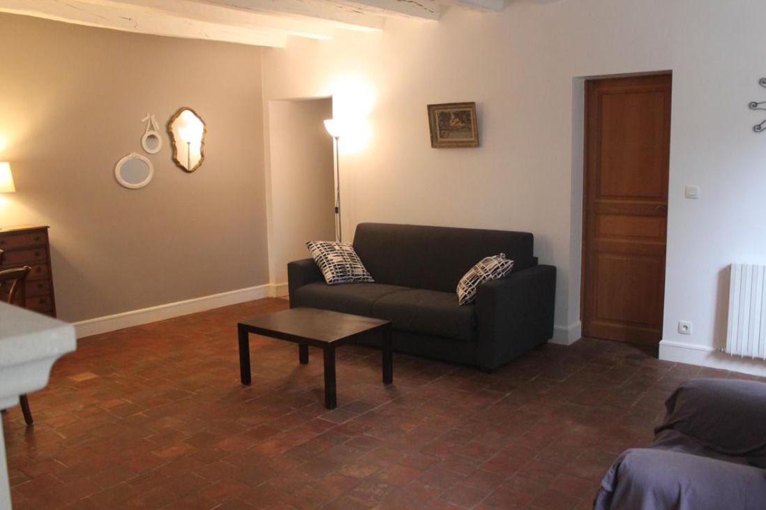 A living room with a dark sofa, a coffee table, and a lamp.