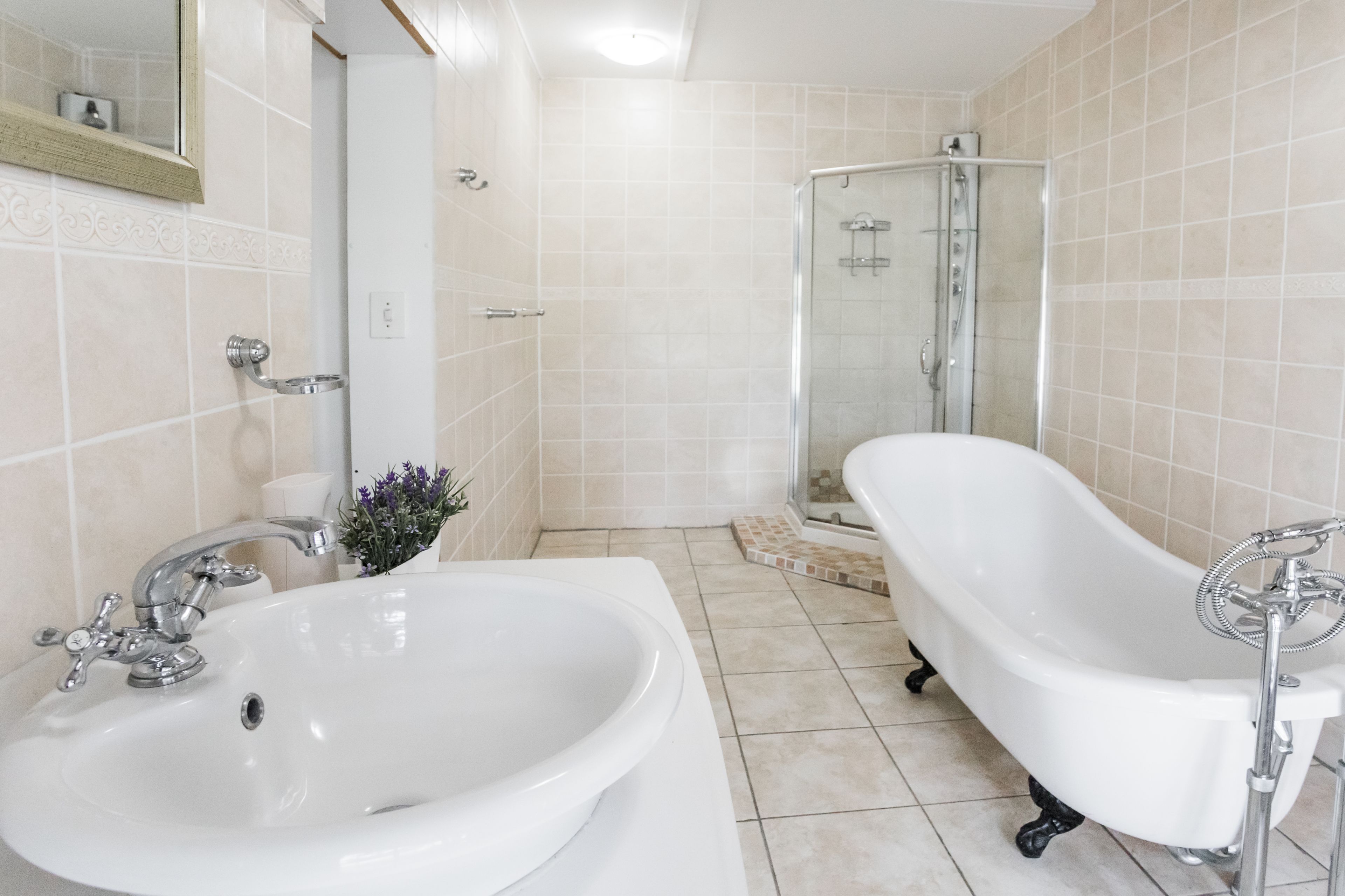 A bathroom with a white sink, a bathtub, and a glass shower enclosure.