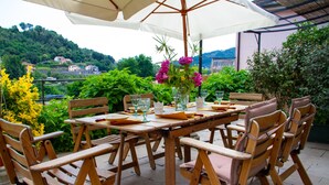 An outdoor dining area with a table set for four, surrounded by wooden chairs with cushioned seats. - B&B Rivarola al Tempo dei Castelli (Carasco)
