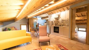 Un salon chaleureux avec un canapé jaune, un fauteuil rose et une table basse en bois.