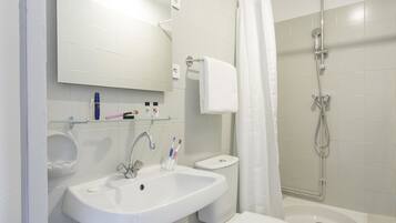 Un baño con lavamanos, inodoro y ducha.