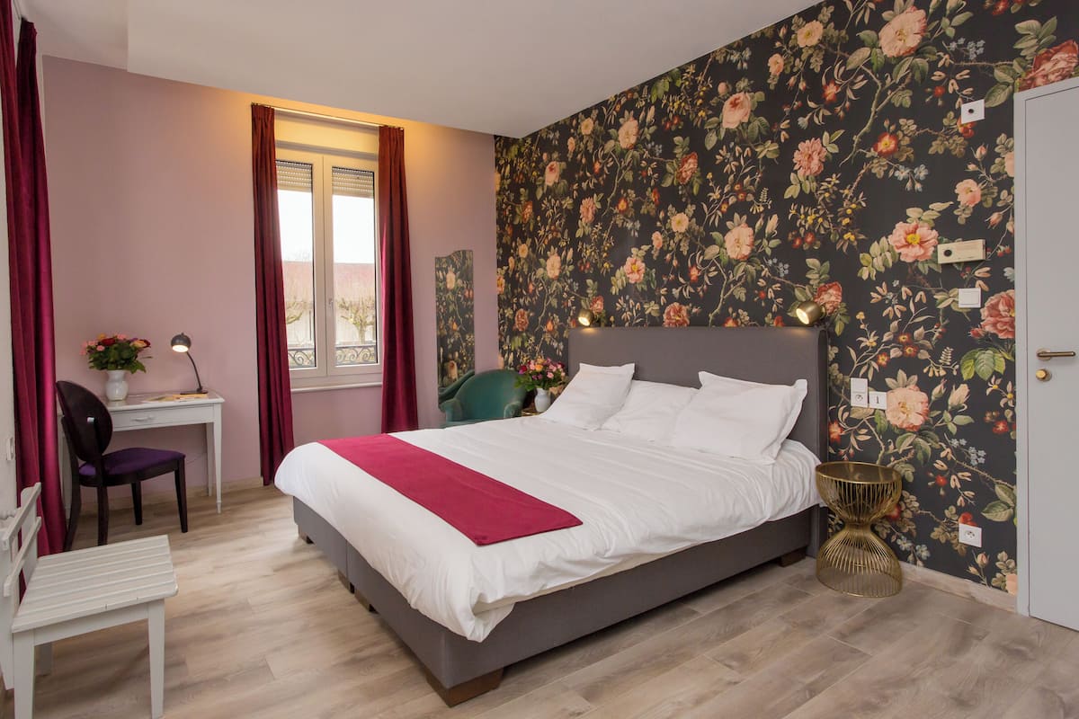 Un dormitorio con cama, escritorio y silla.