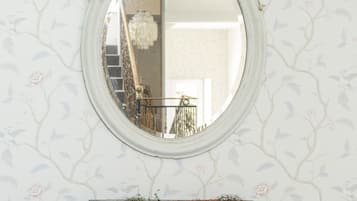 A mirror with an ornate frame and a decorative console table below it.
