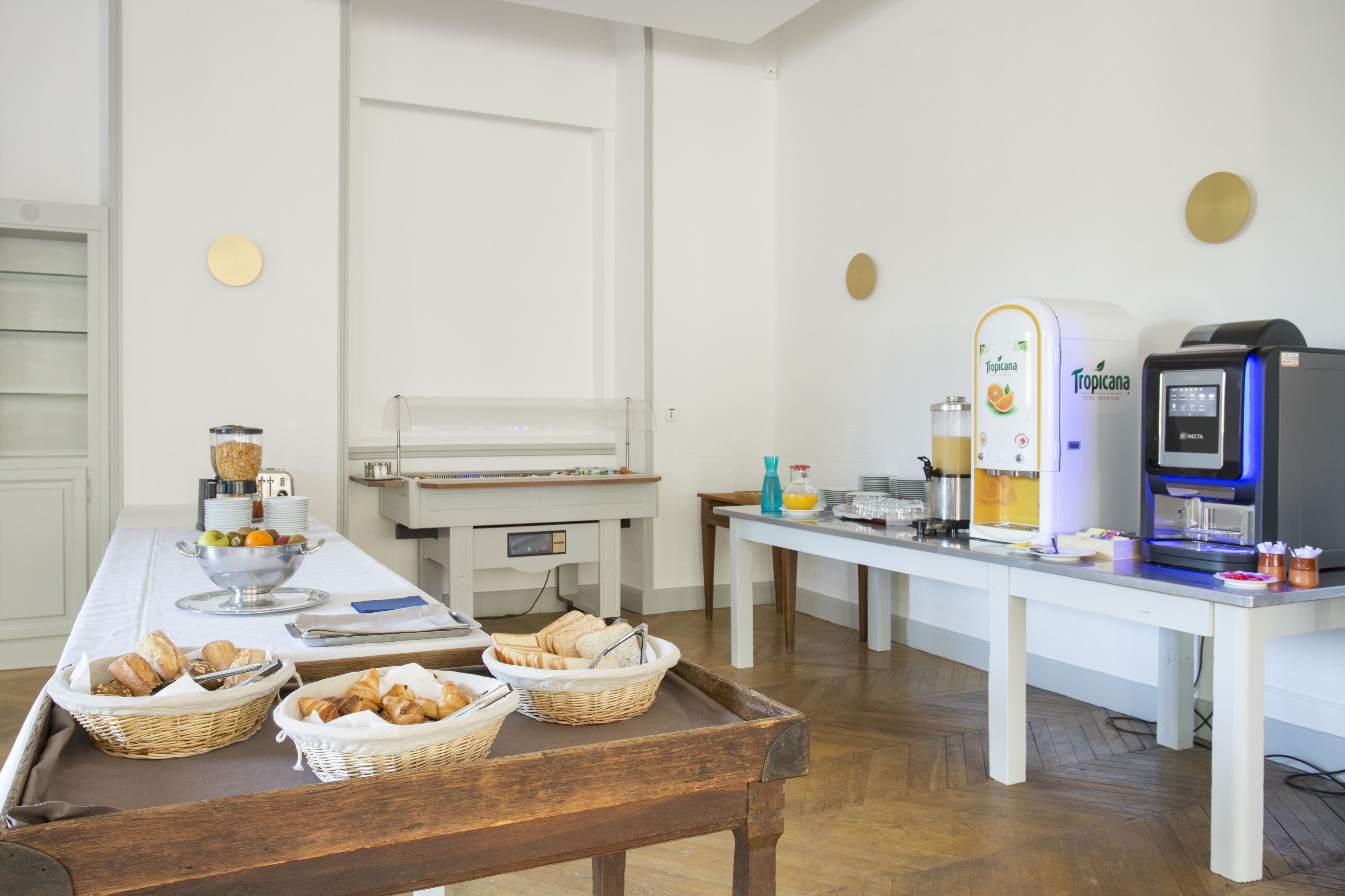 Disposición de un bufé de desayuno con pan, pastelería y dispensadores de zumo.