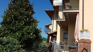 A residential building with balconies, a gated entrance, and potted plants. - B&B Dolce Casa (Castiglione del Lago)