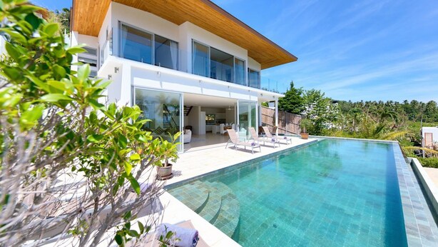 A modern house with a large swimming pool, a wooden deck, and a view of the surrounding greenery. - 3 BR Luxury seaview Bang Po-Zoe (Koh Samui)