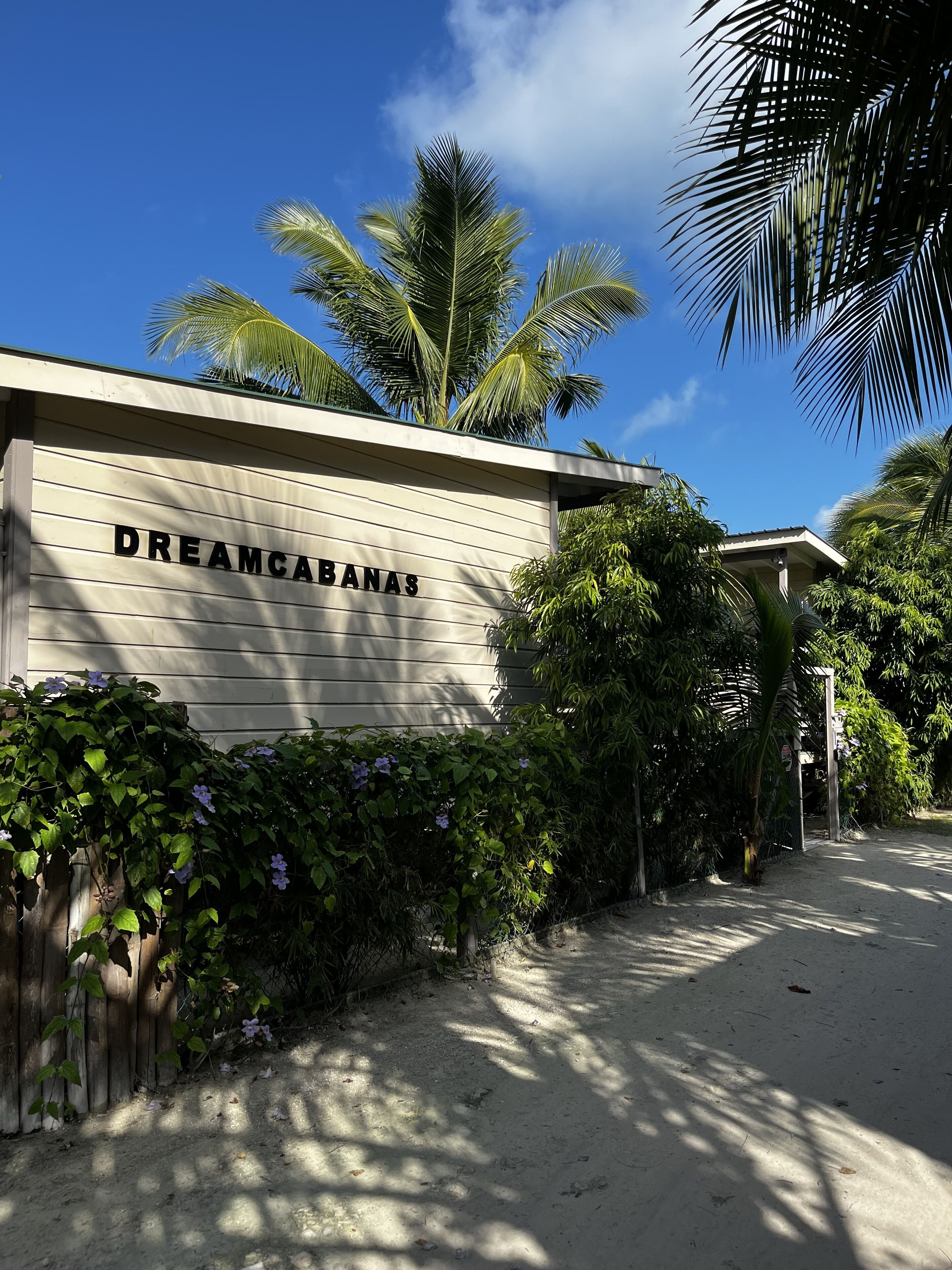 A building with a sign reading "DREAMCABANAS" and a pathway leading to it.
