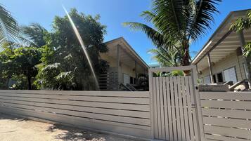 Une entrée fermée par un portail mène à un bâtiment doté d’un toit en pente et d’une enseigne sur laquelle on peut lire : « DREAM CABANAS ».