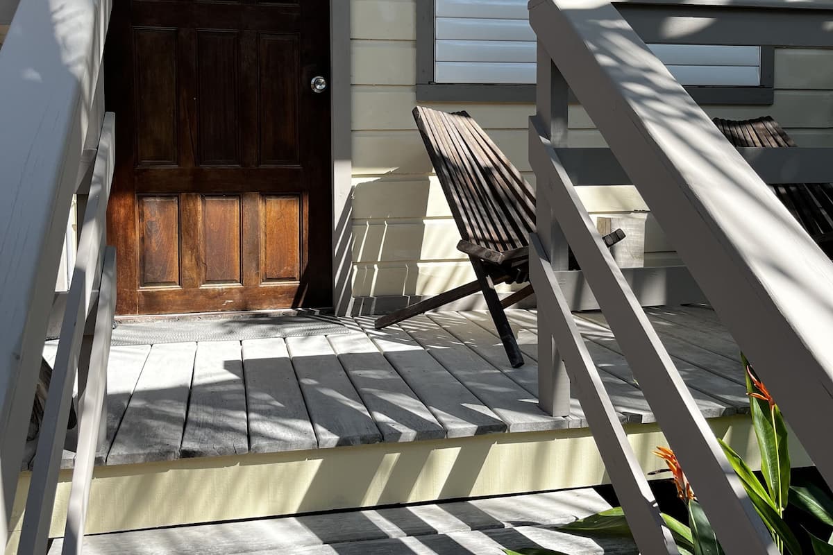 A wooden door with a number '1' above it, a bench, and a railing leading to a porch.