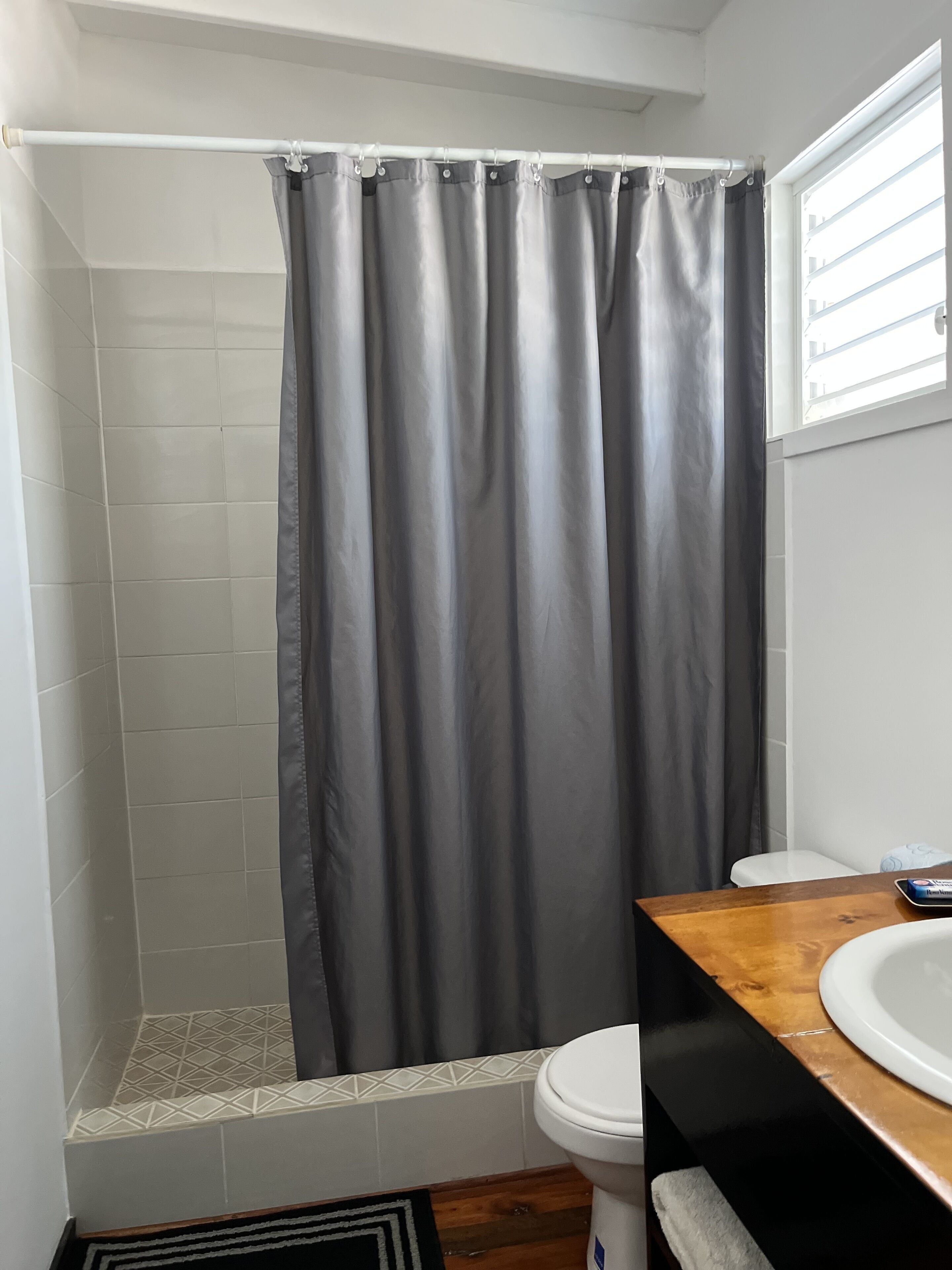 Un baño con ducha, inodoro y lavamanos.