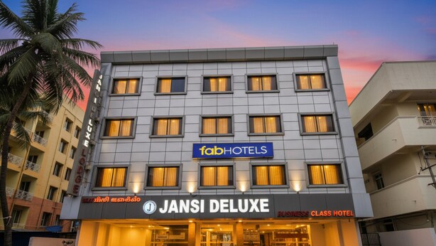 Ein mehrstöckiges Gebäude mit einem Schild für das Hotel 'fabHOTELS' und 'JANSI DELUXE'.