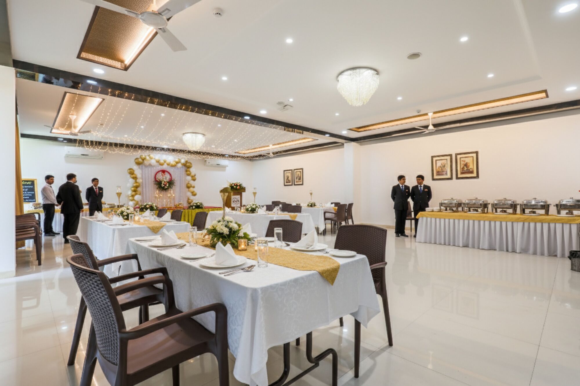 Un salón de banquetes con mesas redondas, sillas y una zona de bufé.