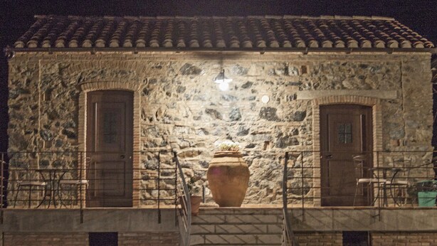 A stone building with two doors and a large vase on the ground. - La Giara B&B (San Demetrio Corone)