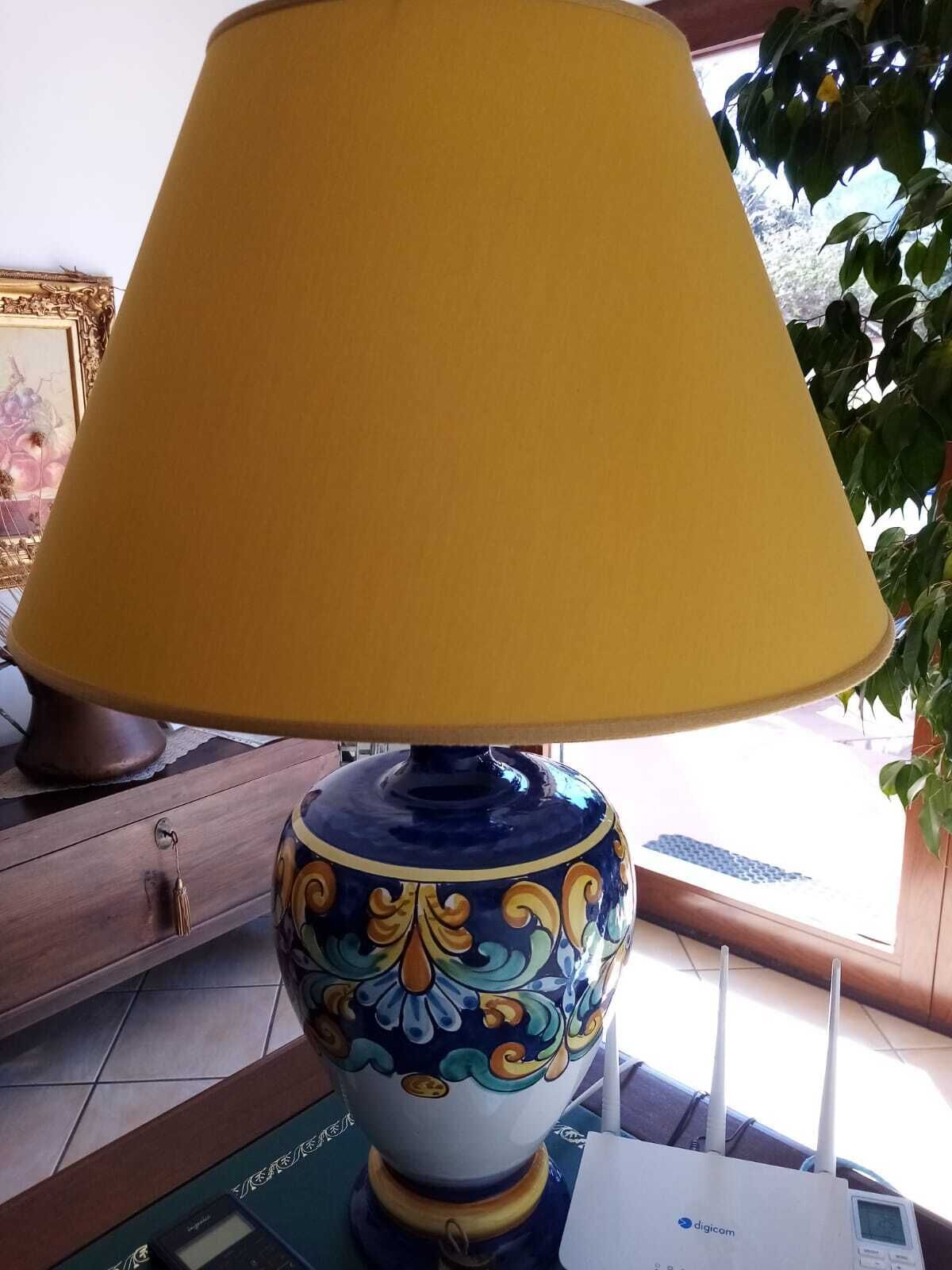 Une lampe de table avec un abat-jour jaune et un pied décoratif en céramique.