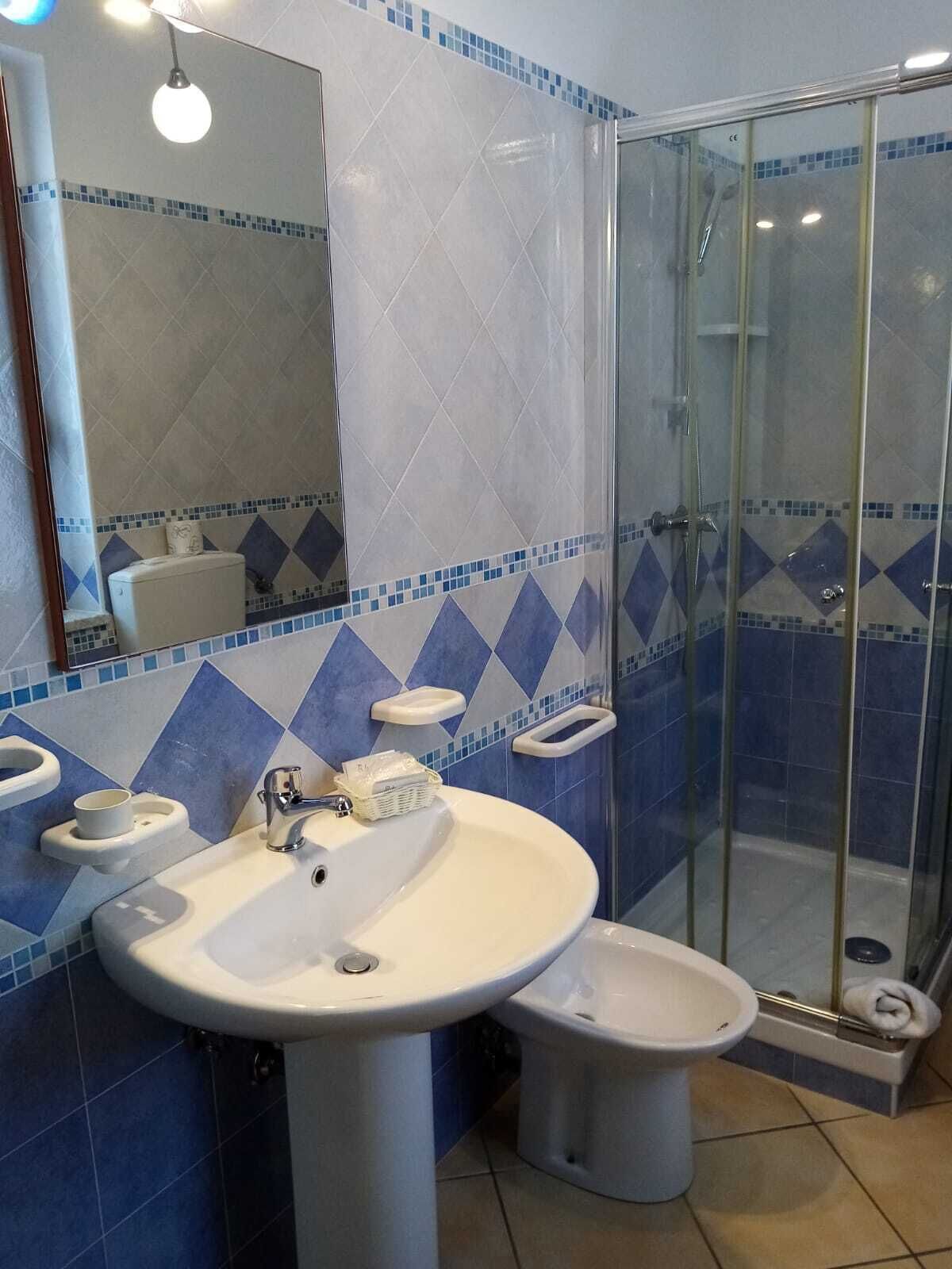 A bathroom with two sinks, a toilet, and a glass shower enclosure.