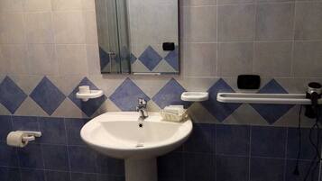 A bathroom with a white sink, a mirror, a towel rack, and a toilet.