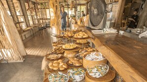 Ein reichhaltiges Buffet mit verschiedenen Speisen, darunter Brot, Gebäck und Wassermelone.