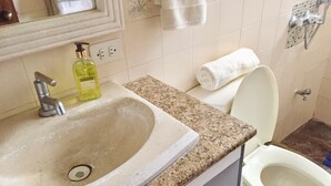 Un baño con lavamanos, inodoro y espejo.