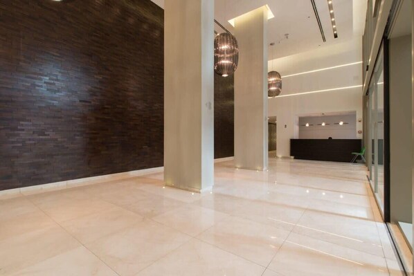 Experience a contemporary lobby with a polished tile floor and a unique contrast of dark and light walls.