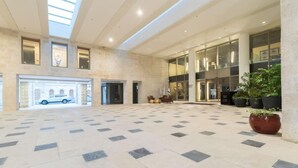 A spacious lobby with a tiled floor, large windows, and a car parked outside.