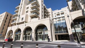 A multi-story building with a modern architectural design, featuring large windows and balconies.
