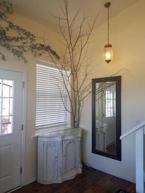 Cozy retreat with a console table, mirror, and window overlooking a serene view.