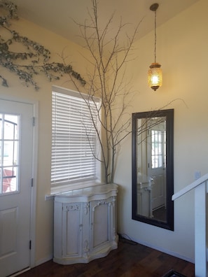 Cozy retreat with a console table, mirror, and window overlooking a serene view.